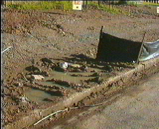 muddy driveway access to building site.  soil in gutter.